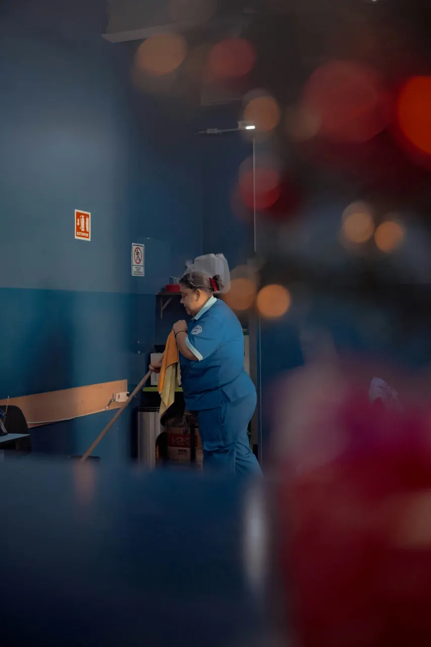 Elemento de limpieza trapeando con esmero un área de trabajo